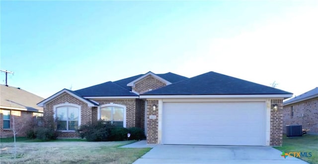 single story home with central AC unit, a garage, and a front lawn