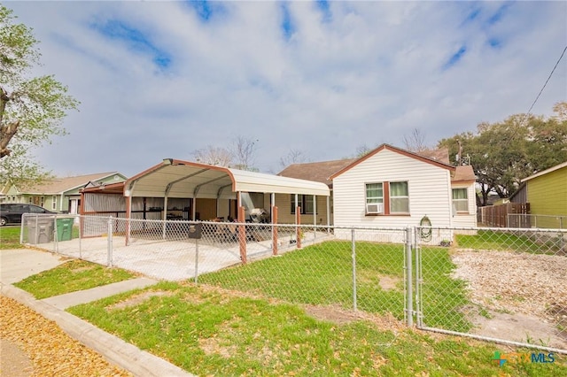 rear view of house featuring a lawn, driveway, a gate, fence, and a detached carport