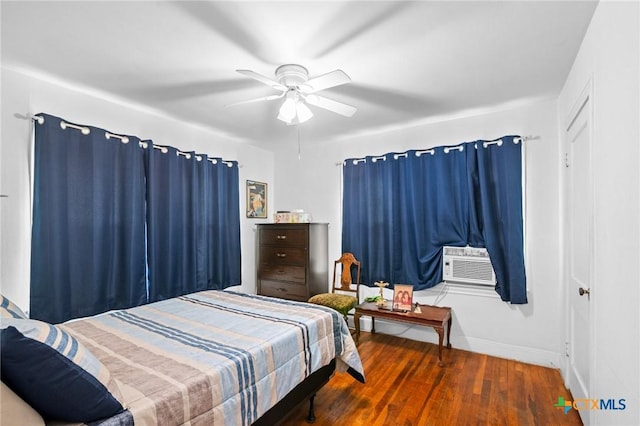 bedroom featuring a ceiling fan, cooling unit, wood finished floors, and baseboards