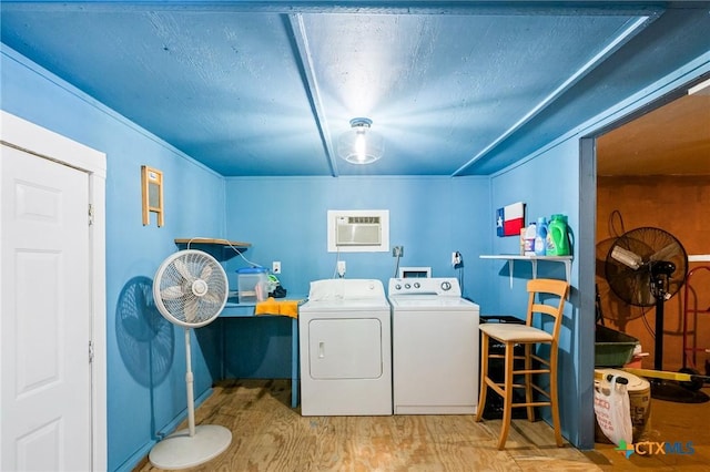 laundry area with washing machine and clothes dryer, wood finished floors, laundry area, and a wall mounted AC