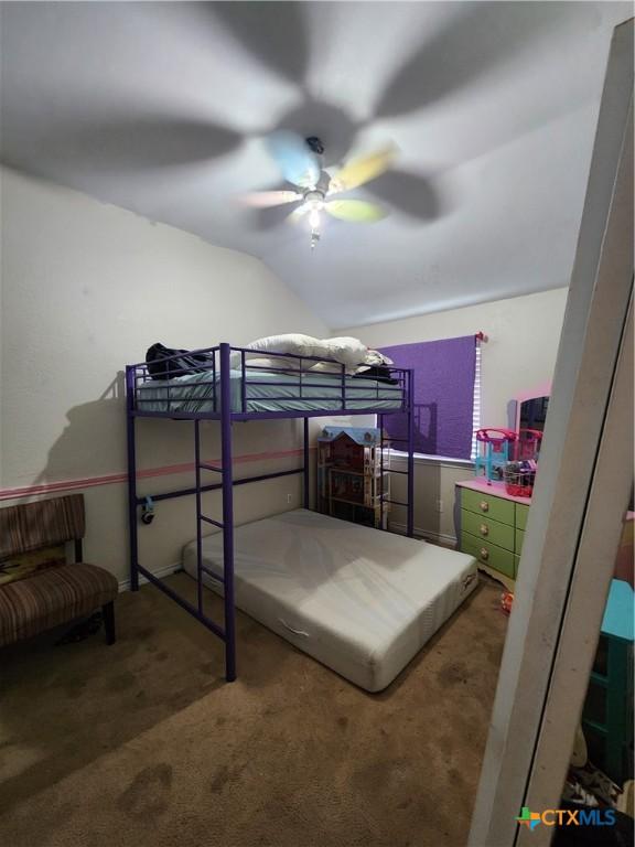 bedroom with carpet floors, vaulted ceiling, and a ceiling fan