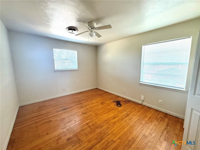 unfurnished room with a textured ceiling, ceiling fan, and light hardwood / wood-style flooring