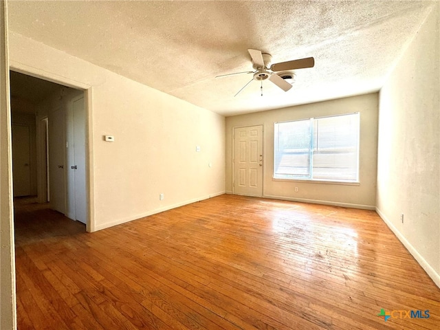 empty room featuring light hardwood / wood-style floors, a textured ceiling, and ceiling fan