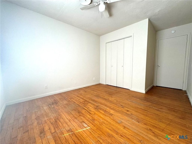 unfurnished bedroom with light wood-style floors, a closet, ceiling fan, and baseboards