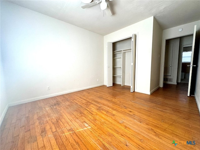 unfurnished bedroom with hardwood / wood-style flooring, ceiling fan, and a closet