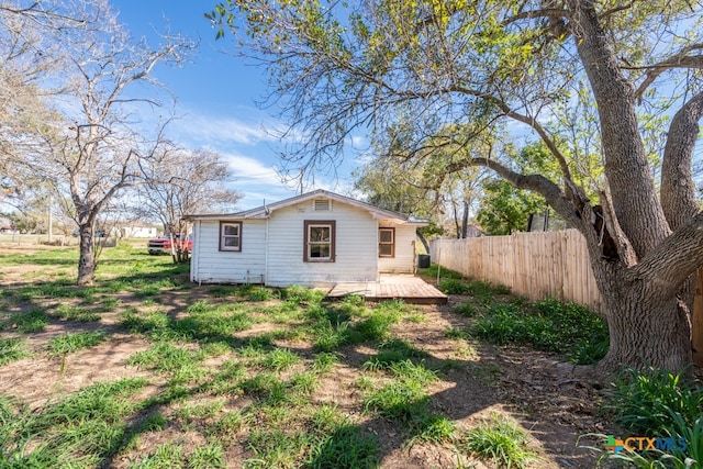 view of side of home featuring a lawn and a wooden deck