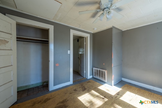 unfurnished bedroom with ceiling fan and a closet