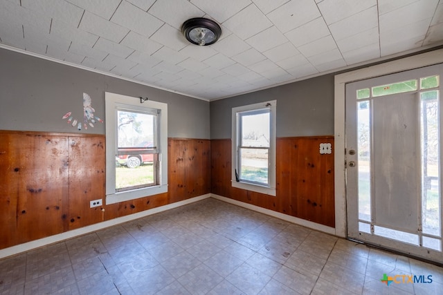 foyer featuring crown molding and wood walls