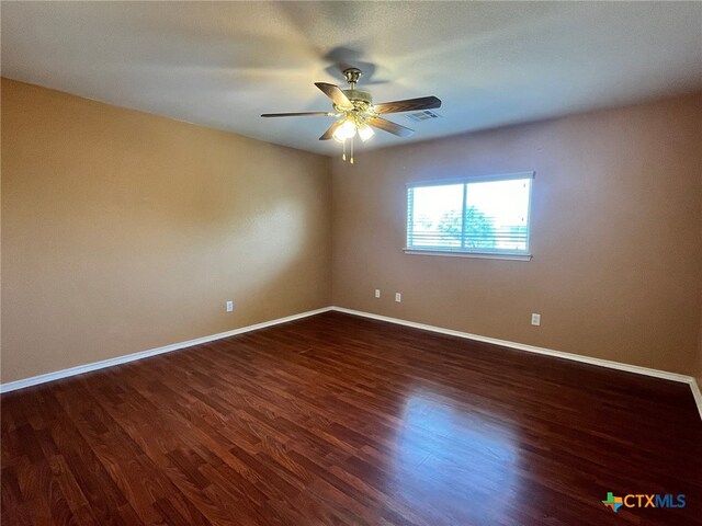 spare room featuring dark hardwood / wood-style floors and ceiling fan