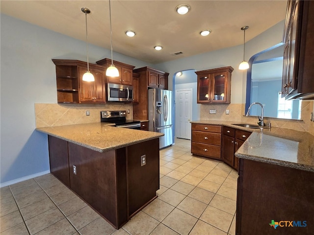 kitchen with kitchen peninsula, backsplash, stainless steel appliances, sink, and pendant lighting