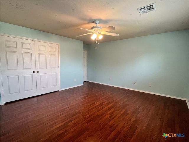 unfurnished bedroom with ceiling fan, a closet, and dark hardwood / wood-style floors