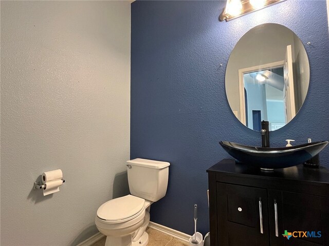 bathroom with tile patterned flooring, vanity, and toilet