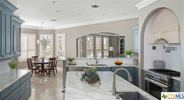 kitchen featuring backsplash, light stone countertops, sink, and stainless steel appliances