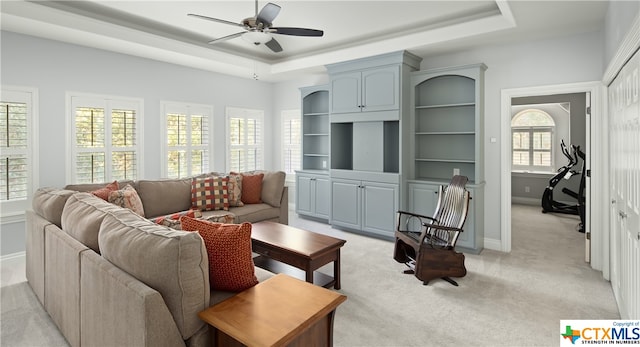 carpeted living room featuring ceiling fan and a raised ceiling