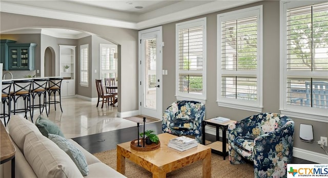 living room with built in shelves and ornamental molding