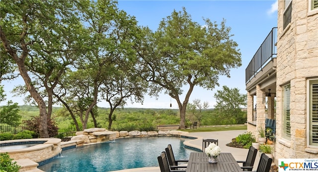 view of pool with an in ground hot tub, pool water feature, and a patio