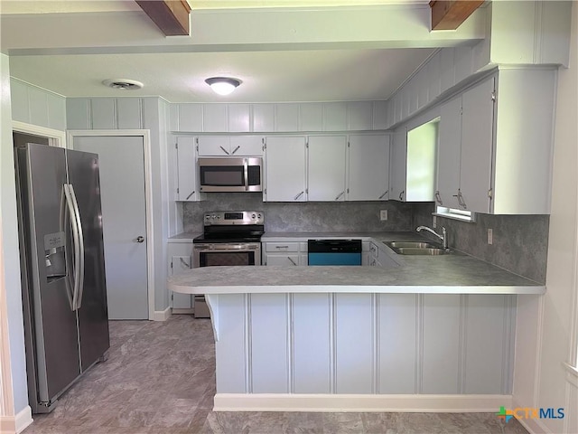 2303 Bon Aire Ave, Victoria, TX 77901 - kitchen with stainless steel appliances, a peninsula, light countertops, and backsplash