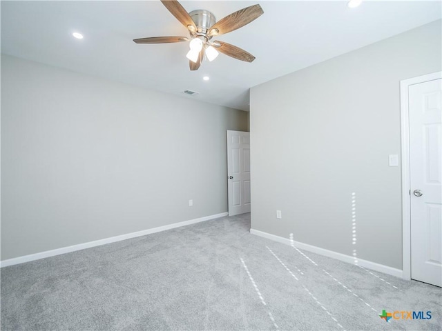 spare room featuring light carpet and ceiling fan