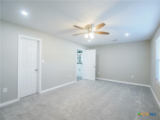 carpeted spare room with ceiling fan