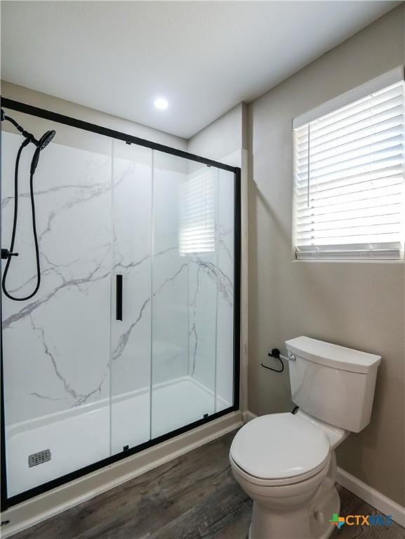 bathroom featuring a shower with shower door, toilet, and wood-type flooring