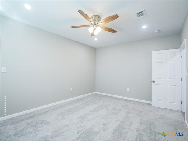 spare room with ceiling fan and light carpet