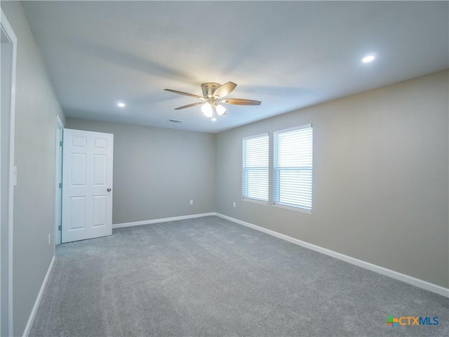 carpeted spare room featuring ceiling fan