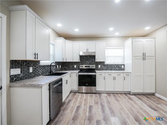 kitchen with stainless steel electric range, white cabinets, sink, black dishwasher, and light hardwood / wood-style floors