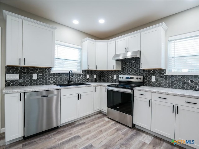 kitchen with white cabinetry, plenty of natural light, light wood-type flooring, and appliances with stainless steel finishes