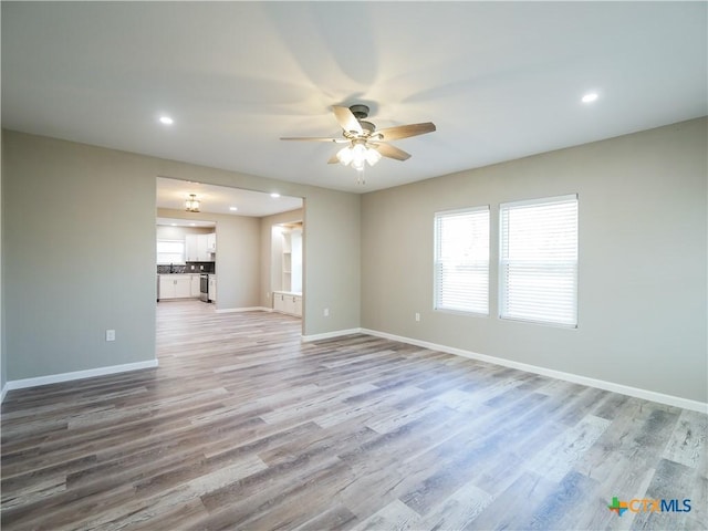 unfurnished living room with ceiling fan and light hardwood / wood-style flooring