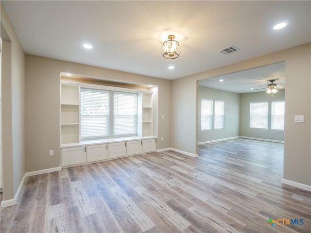 unfurnished living room featuring ceiling fan, light hardwood / wood-style floors, and built in features