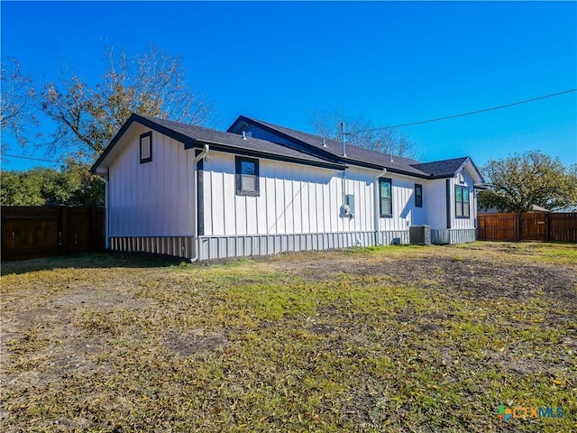 view of side of home with cooling unit and a lawn