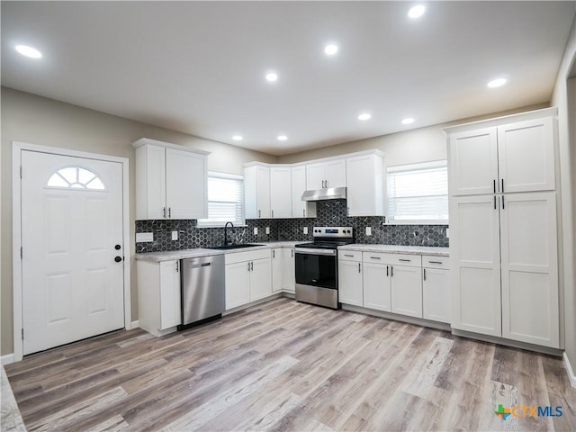 kitchen featuring white cabinetry, a wealth of natural light, sink, and appliances with stainless steel finishes