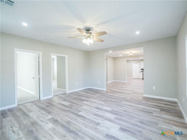 spare room with ceiling fan and light wood-type flooring