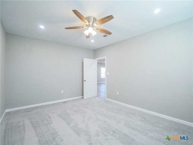 empty room featuring ceiling fan and light colored carpet