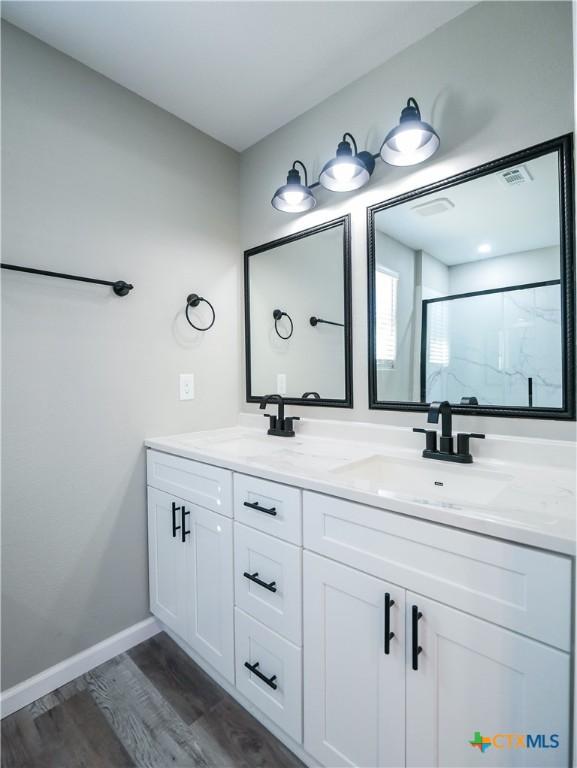 bathroom featuring vanity, hardwood / wood-style flooring, and a shower with door