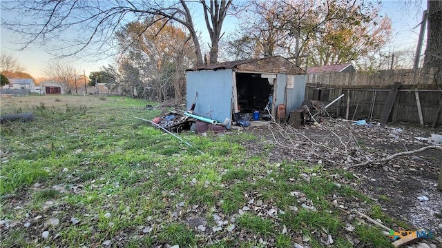 view of yard with an outbuilding, a storage unit, and fence