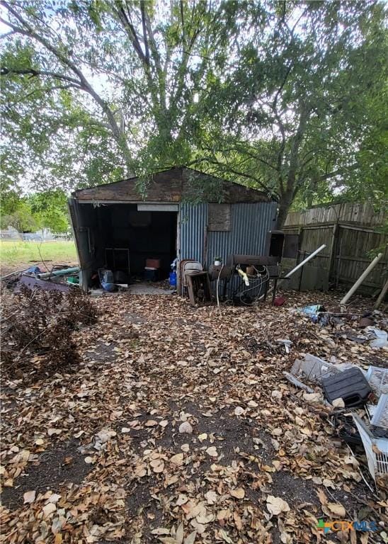 view of outbuilding featuring fence and an outbuilding