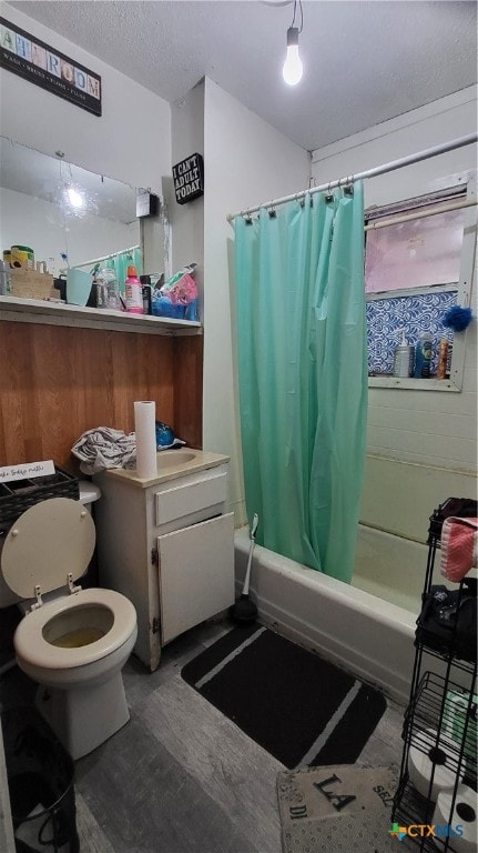 bathroom with toilet, shower / bath combo, wood-type flooring, and a textured ceiling