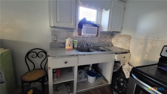 kitchen with white cabinetry, stainless steel range with electric stovetop, light countertops, a sink, and decorative backsplash