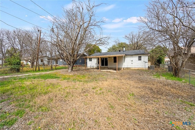 back of house featuring central AC and fence