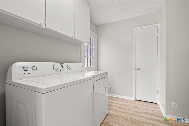 washroom featuring cabinet space, baseboards, independent washer and dryer, a textured ceiling, and light wood-style floors