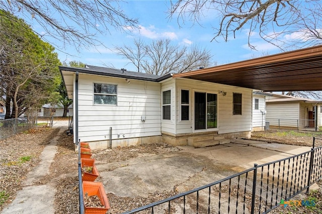 rear view of house with entry steps and fence