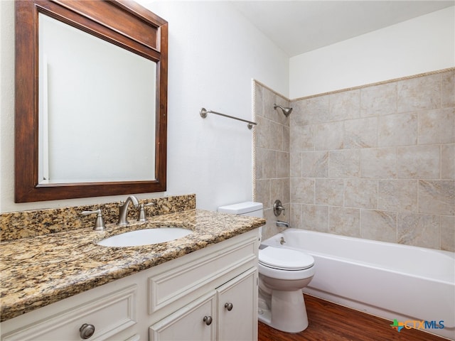 full bath with toilet, bathtub / shower combination, wood finished floors, and vanity