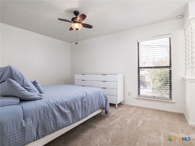 carpeted bedroom with ceiling fan and baseboards