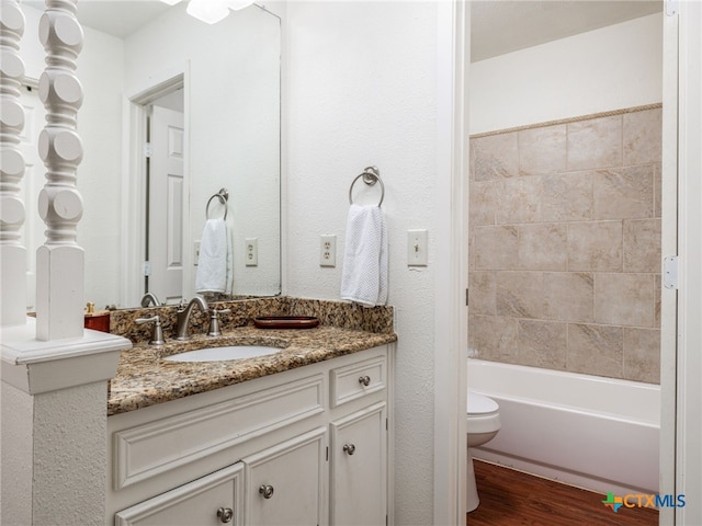 bathroom featuring toilet, wood finished floors, and vanity