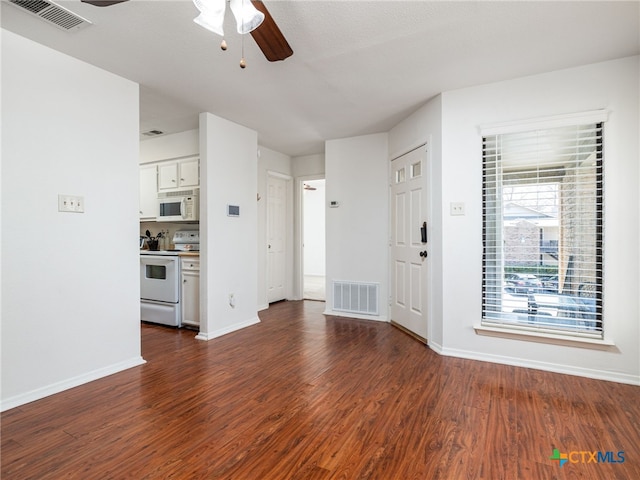 unfurnished living room with visible vents, dark wood finished floors, and a ceiling fan