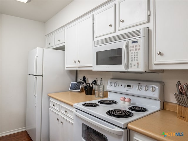 kitchen featuring light countertops, white appliances, white cabinets, and baseboards