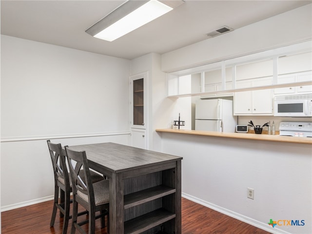 dining space featuring baseboards, visible vents, and dark wood-type flooring