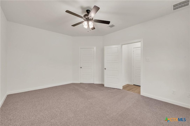unfurnished bedroom with carpet, visible vents, baseboards, and ceiling fan