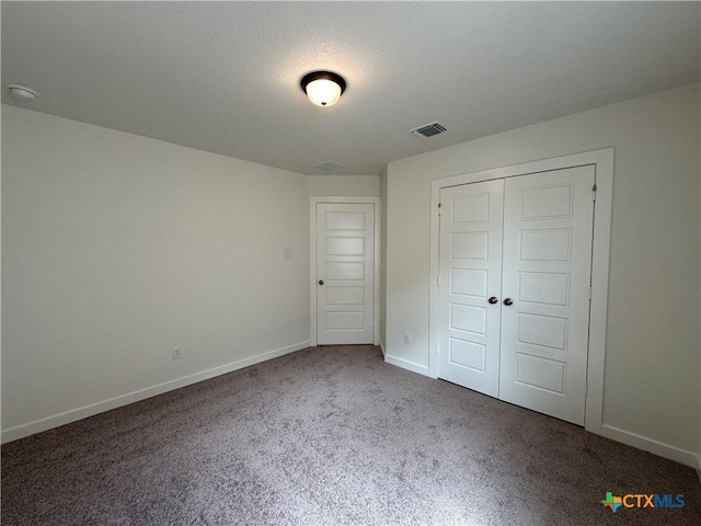 unfurnished bedroom featuring carpet, visible vents, a closet, and baseboards